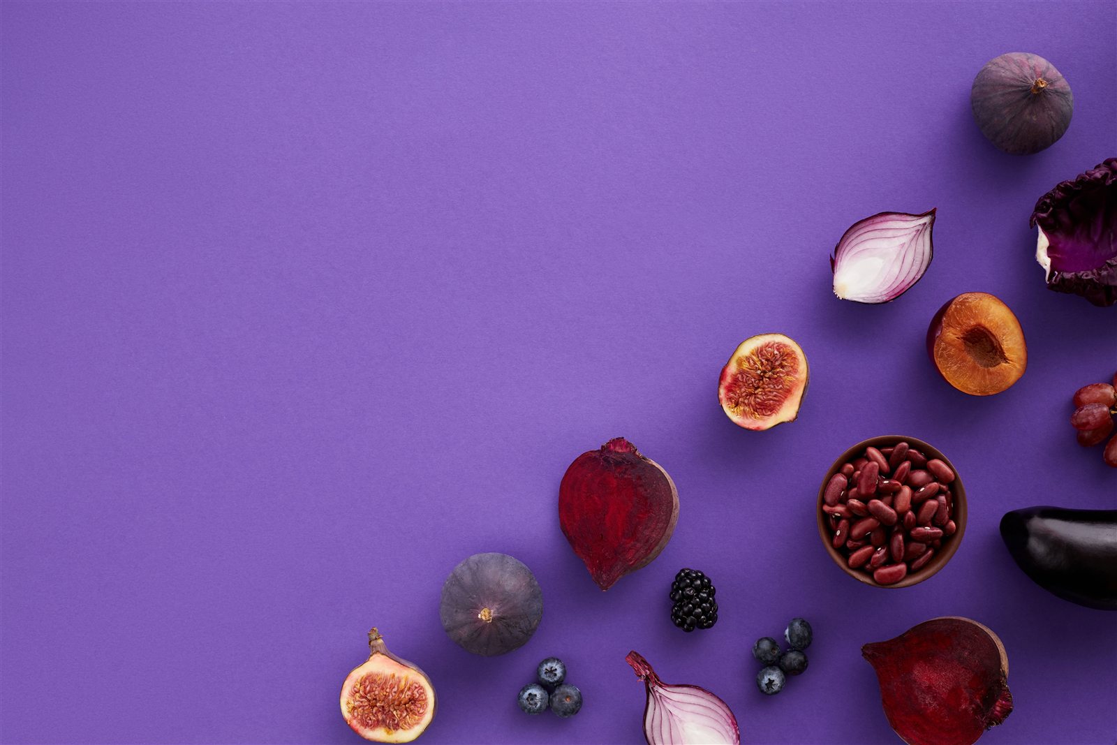 Frutas y vegetales de colores sobre un fondo violeta